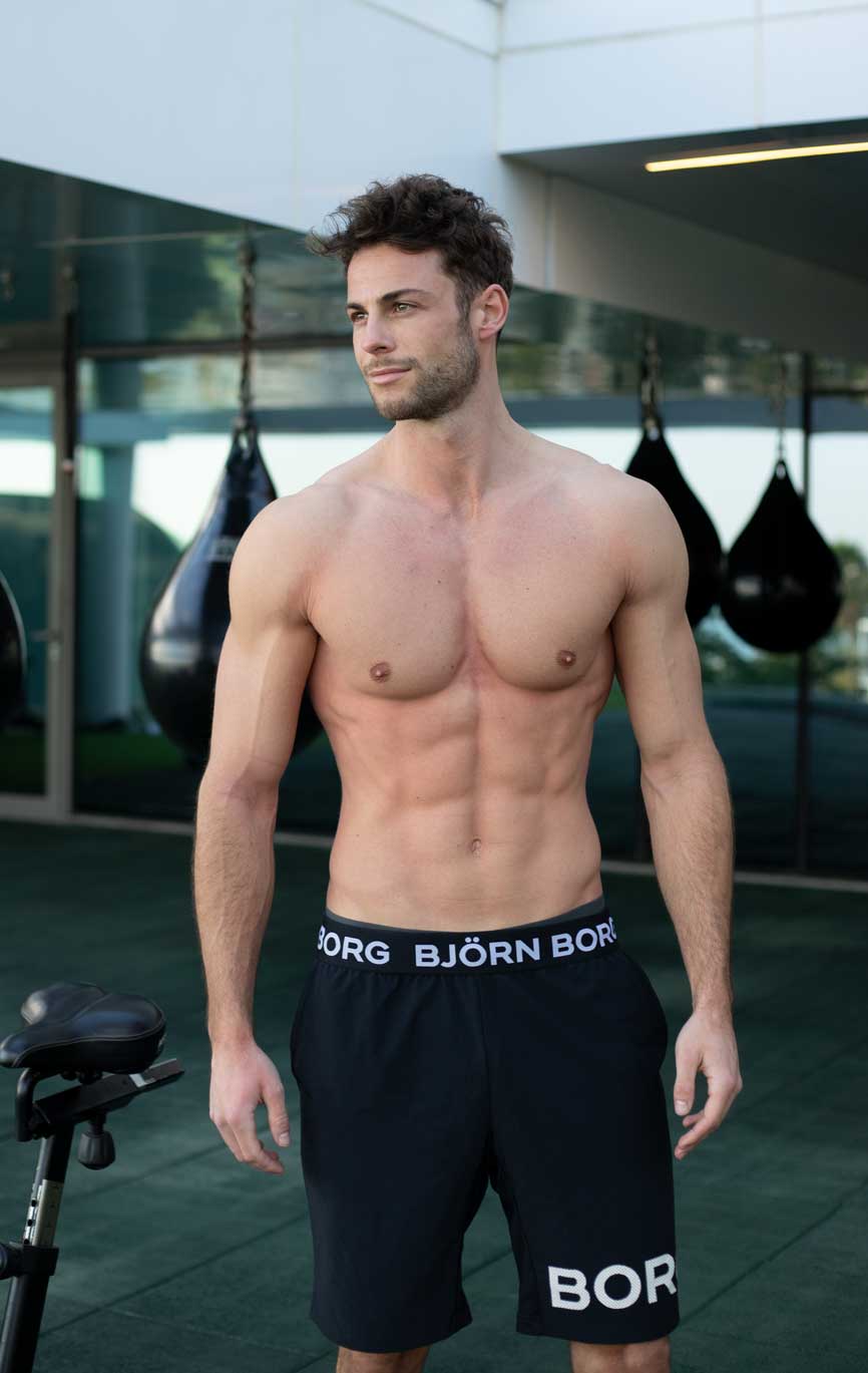 Coach Dennis Boeer steht lächelnd im Fitnessstudio